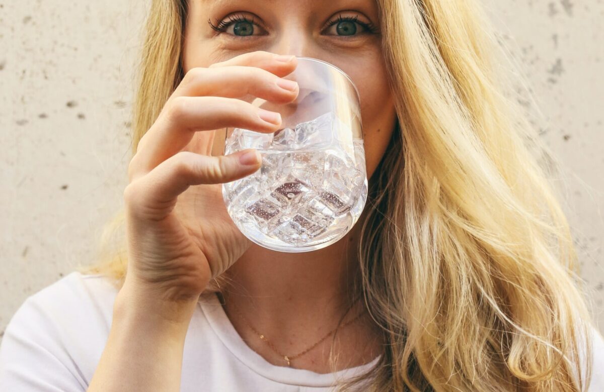 mulher loira bebendo copo de água